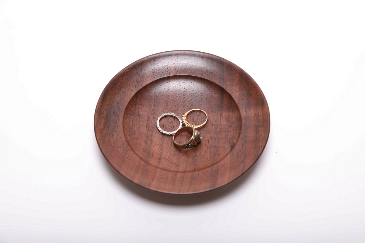 Three rings resting in a hand-turned black walnut ring dish for scale, top view, 5 7/8 inch diameter