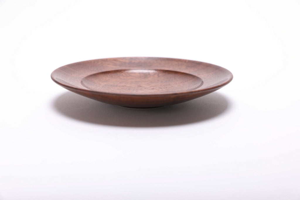 Side view of quartersawn black walnut ring dish highlighting dark growth ring transition lines along the rim