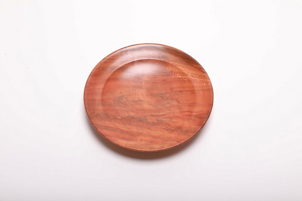 Top view of hand-turned wild black cherry burl ring dish showing warm pink-orange grain with swirling burl figure, 5 3/8 inches
