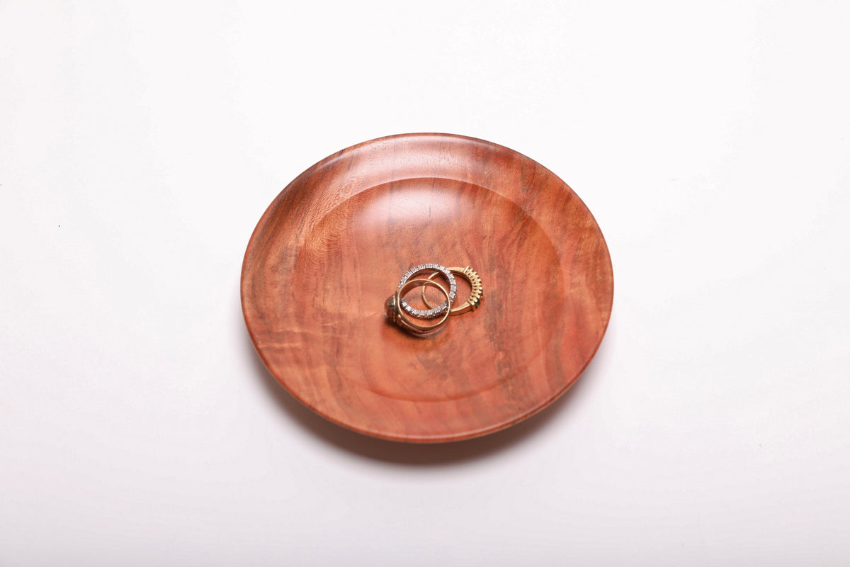 Three gold rings resting in a hand-turned wild black cherry burl ring dish for scale, top view, 5 3/8 inch diameter