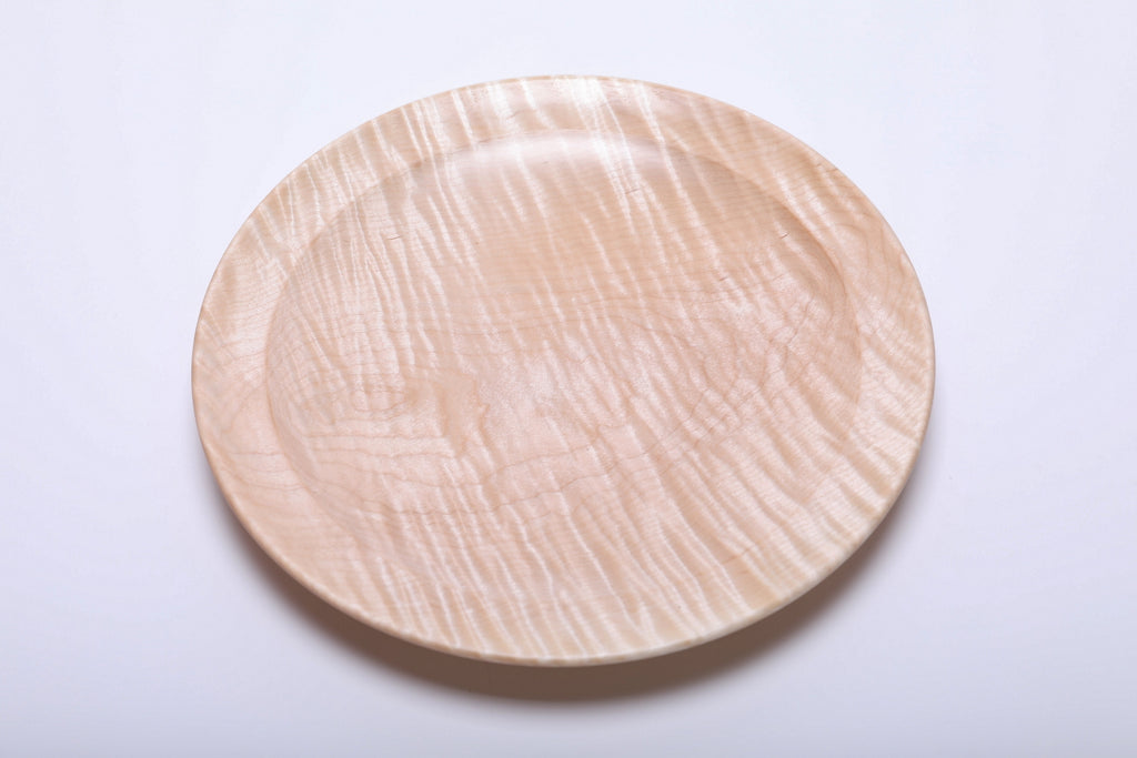 Top view of handmade tiger maple platter showing pronounced curly growth ring lines and warm honey coloration