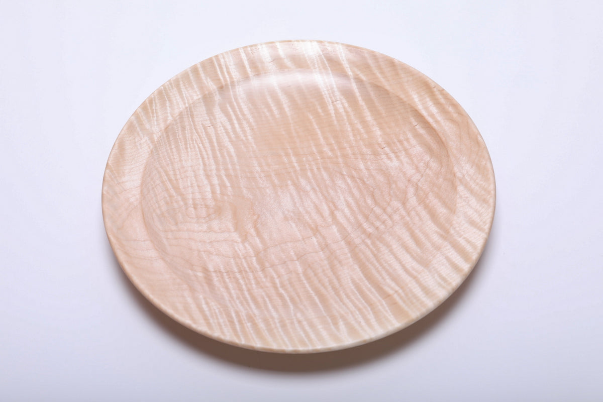 Top view of handmade tiger maple platter showing pronounced curly growth ring lines and warm honey coloration