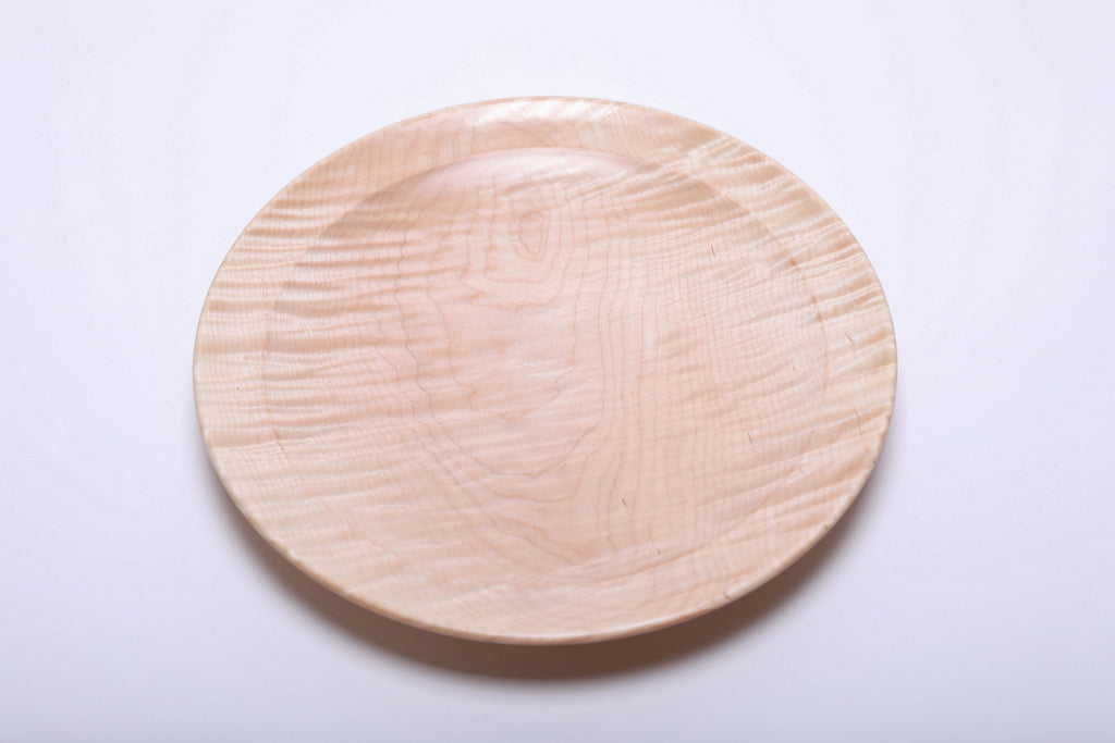 Top view of tiger maple wooden platter showing dense curly figure and pale cream tones with honey highlights