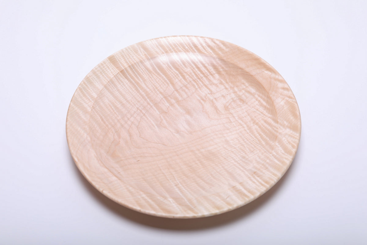 Top view of hand-turned tiger maple platter showing full grain pattern with curly figure and undercut rim