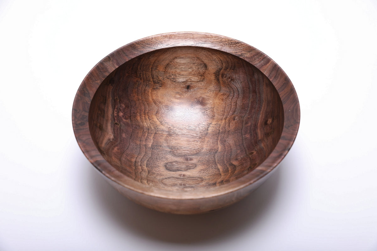 Top view of handmade black walnut bowl showing snowman figure, bud scars, and spalted grain pattern with natural oil finish
