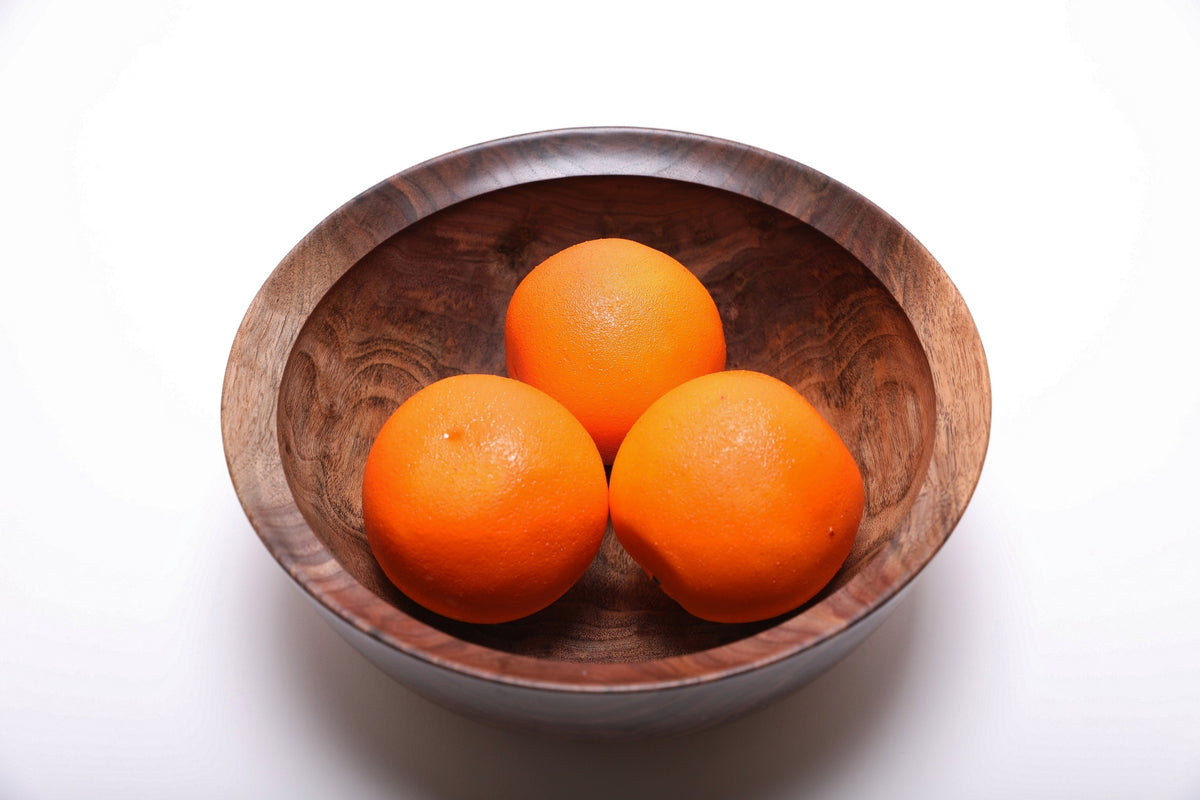 Three oranges resting in a hand-turned spalted black walnut bowl for scale, top view, 9 3/8 inch diameter