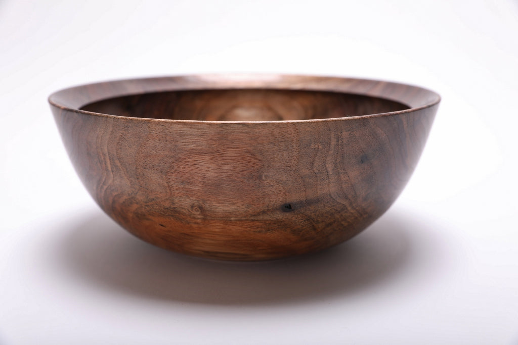 Side view of spalted wild black walnut bowl showing curved taper, undercut rim, and rich brown grain detail