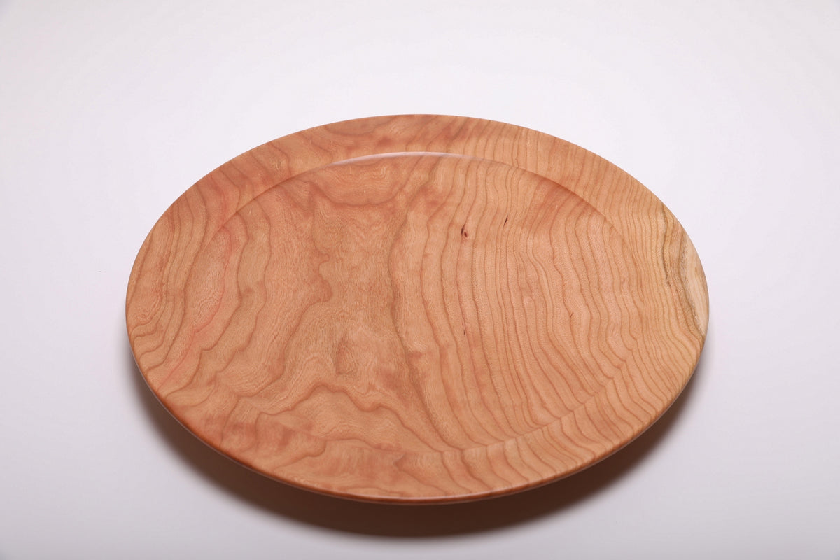Top view of curly wild black cherry platter highlighting flowing curly grain pattern and warm rose-pink tones with natural oil finish