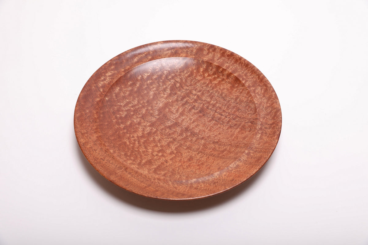 Top view of pommele sapele bowl highlighting full-surface chatoyant dapple figure with warm copper and mahogany tones shifting in the light