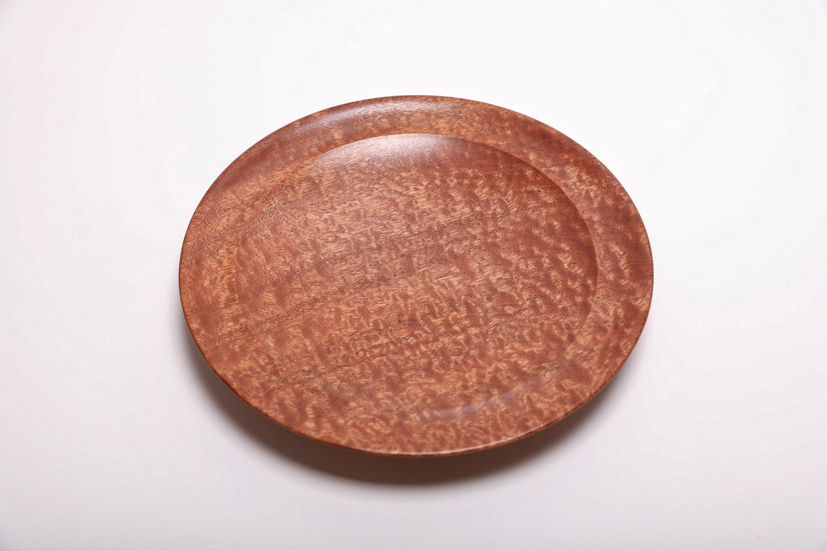 Top view of pommele sapele bowl showing swirling chatoyant dapple figure with warm reddish-brown mahogany tones, 10 inch diameter