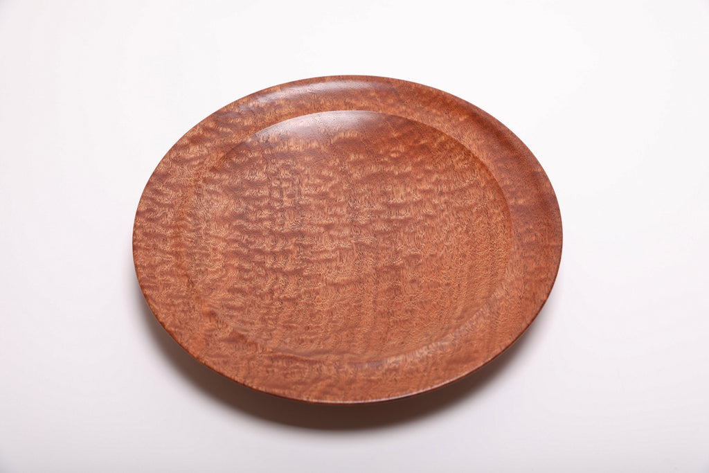 Top view of handmade pommele sapele wooden bowl with dense chatoyant dapple figure and warm reddish-brown tones, 10 inch diameter