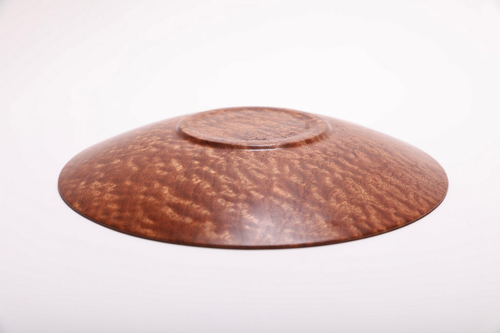 Bottom view of handmade pommele sapele wooden bowl showing raised foot and natural oil finish