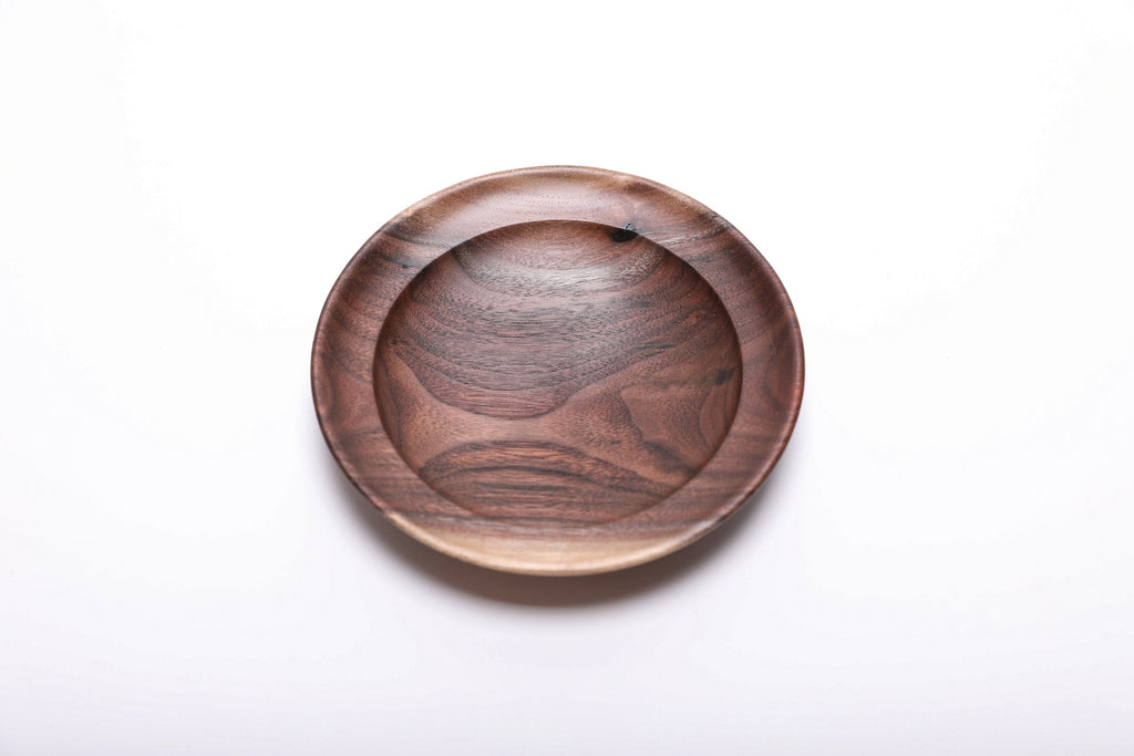 Top view of hand-turned wild black walnut wooden ring dish showing dark chocolate heartwood with bud scar detail and undercut rim, 4 7/8 inches