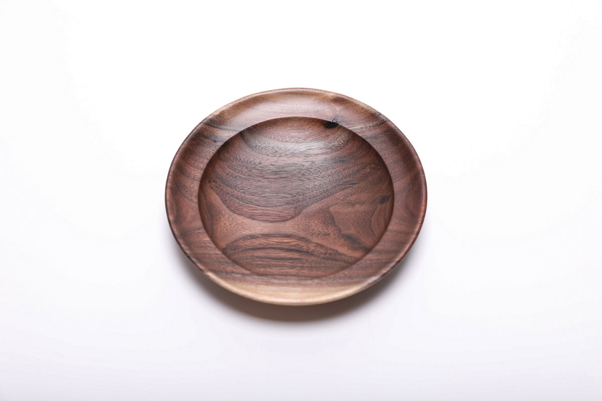 Top view of hand-turned wild black walnut wooden ring dish showing dark chocolate heartwood with bud scar detail and undercut rim, 4 7/8 inches