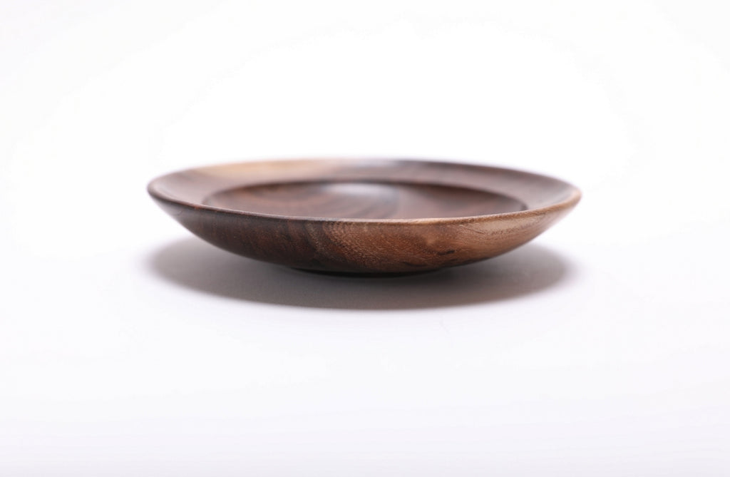 Side view of wild black walnut jewelry dish highlighting contrasting sapwood rim and dark chocolate heartwood exterior with raised foot