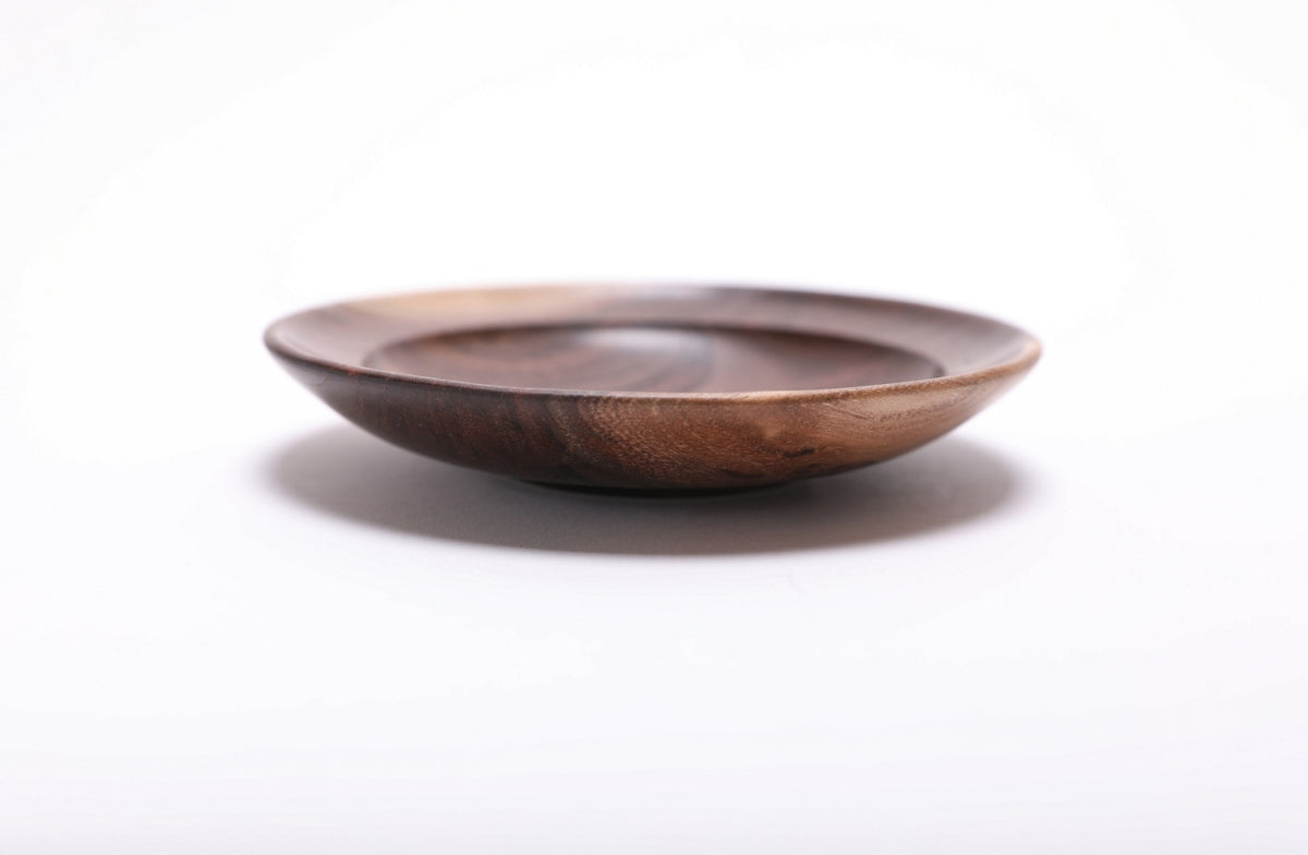 Side view of wild black walnut jewelry dish highlighting contrasting sapwood rim and dark chocolate heartwood exterior with raised foot