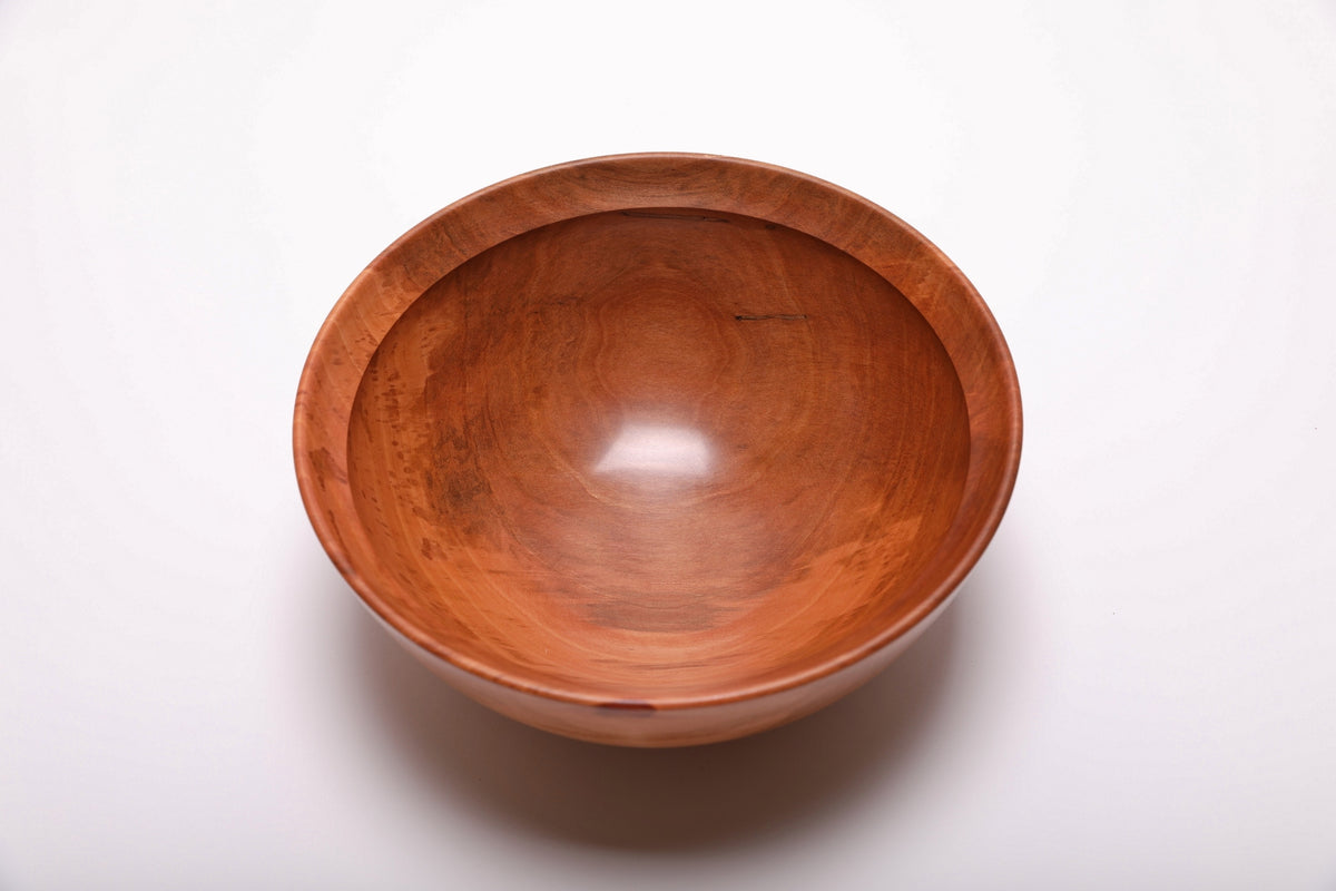 Top view of a hand-turned Bradford pear wooden bowl with reddish-brown and salmon tones