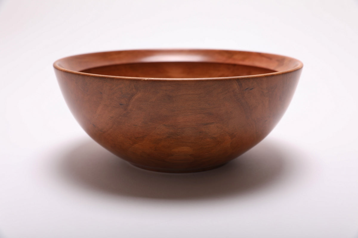 Side view of a Bradford pear wooden bowl with a curved taper, undercut rim, and raised foot