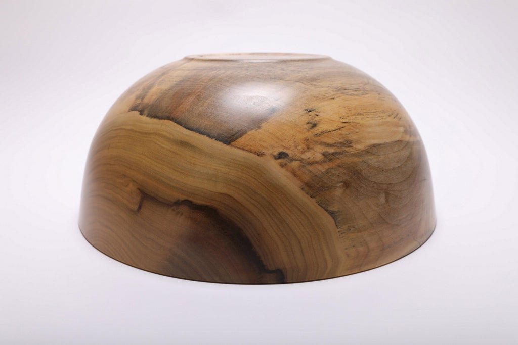 Bottom view showing the bowl’s raised foot and natural wood grain