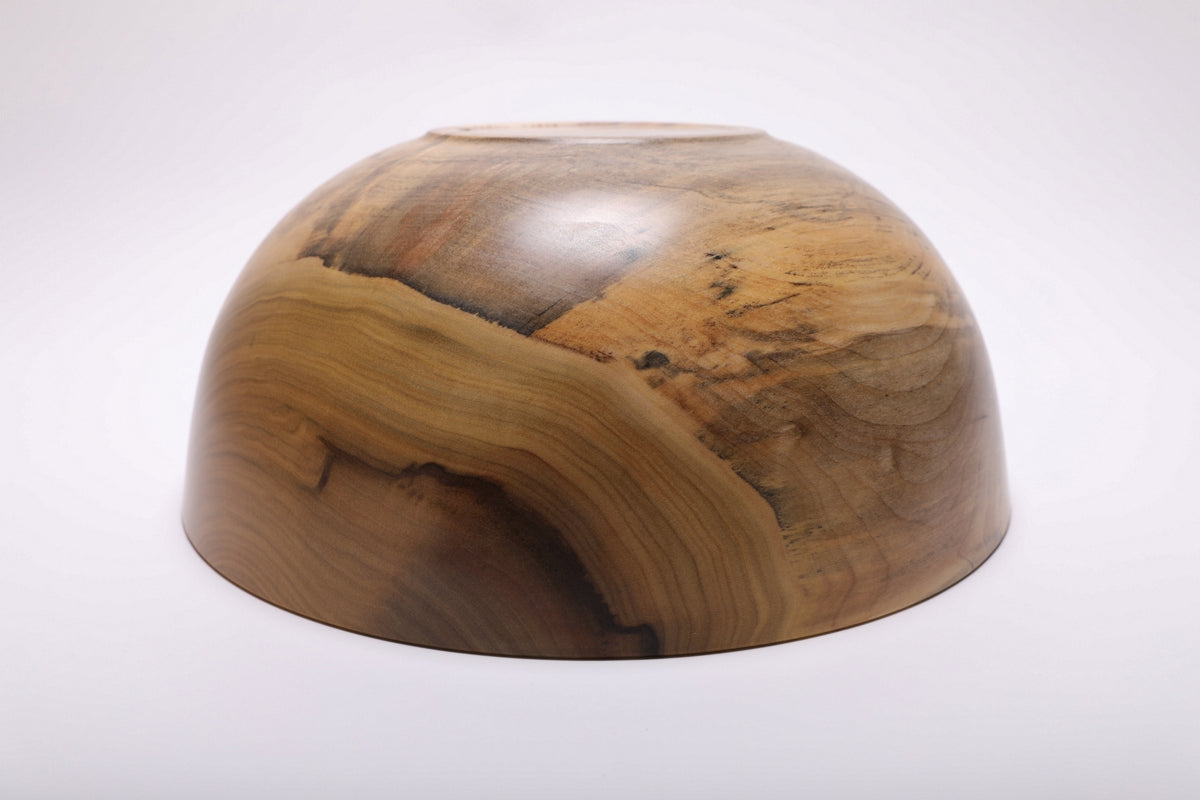 Bottom view showing the bowl’s raised foot and natural wood grain