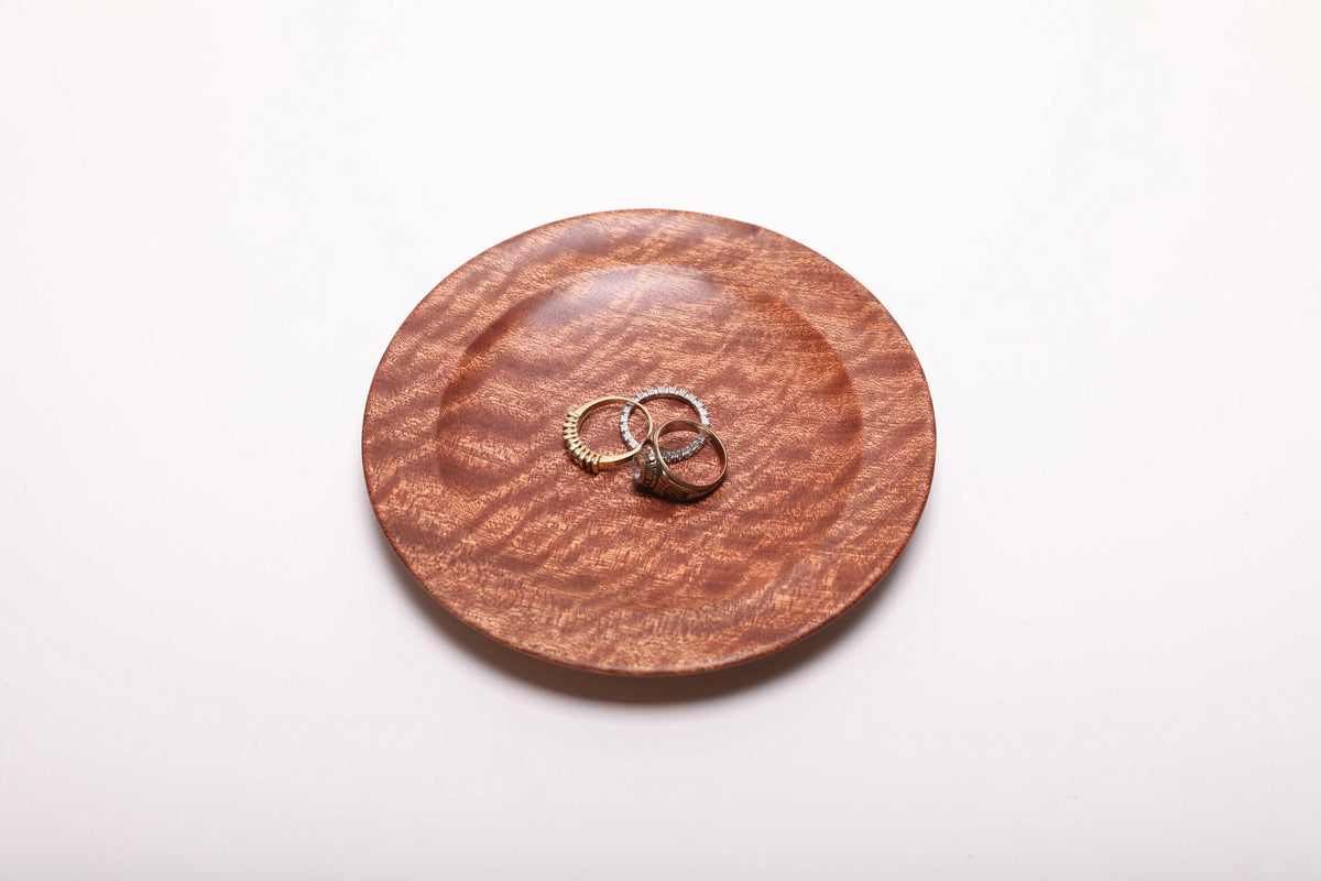 Three rings arranged in a pommele sapele ring dish, shown from above