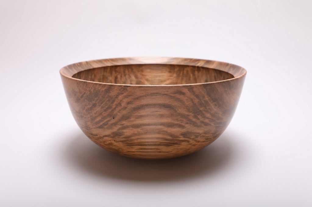 Side view of the maple bowl showing arched grain bands, curved walls, and a rounded rim
