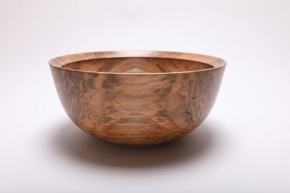 Side view of the spalted maple bowl showing a golden central panel bordered by darker streaks