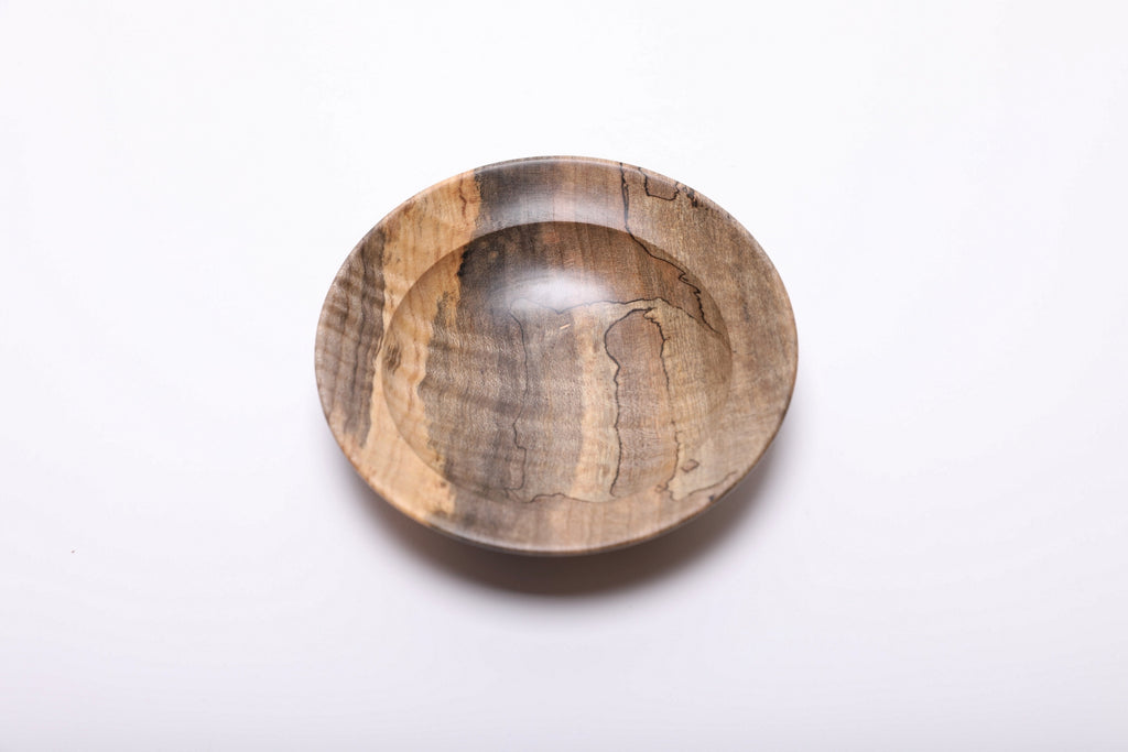 Top view of the maple ring dish with a golden stripe along the left rim and winding black spalting lines inside.