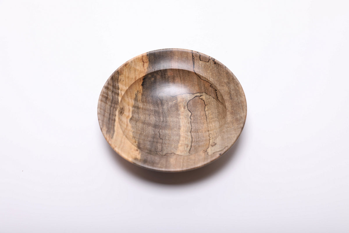Top view of the maple ring dish with a golden stripe along the left rim and winding black spalting lines inside.