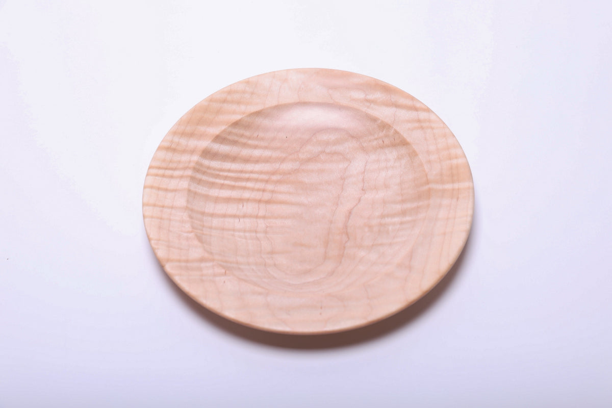 Tiger maple dish viewed from above, rotated to show horizontal bands of light and dark figured grain.