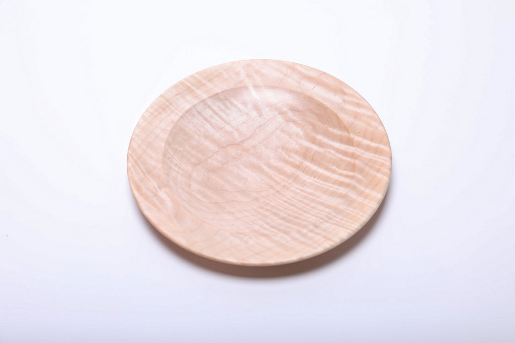 Tiger maple dish viewed from above, with wavy grain bands catching the light across the right side.