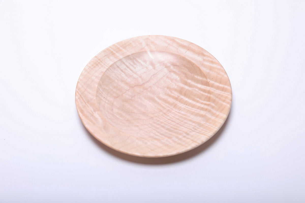 Tiger maple dish viewed from above, with wavy grain bands catching the light across the right side.