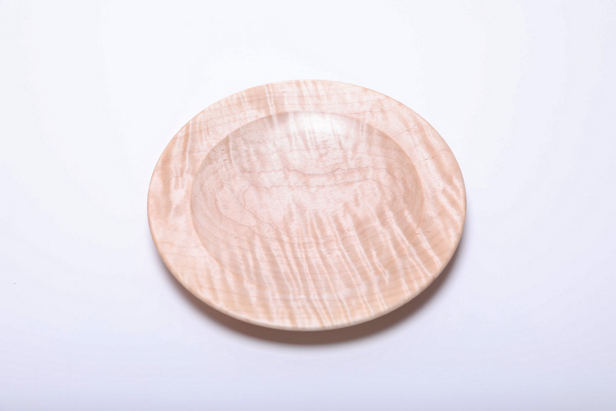 Top view of tiger maple dish rotated to show pronounced vertical tiger stripes across the center and front rim.
