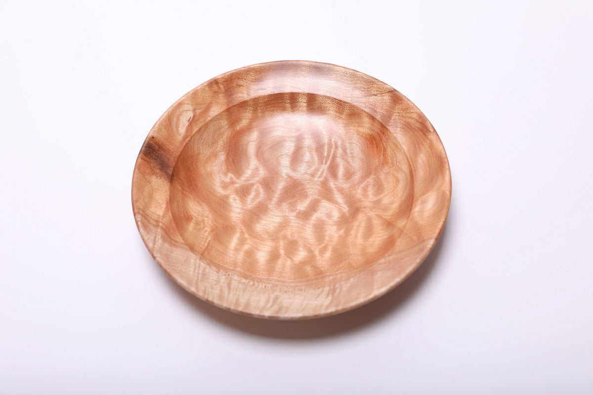 Top view of a pillow quilted maple ring dish with luminous honey-colored grain and a broad, rounded rim.