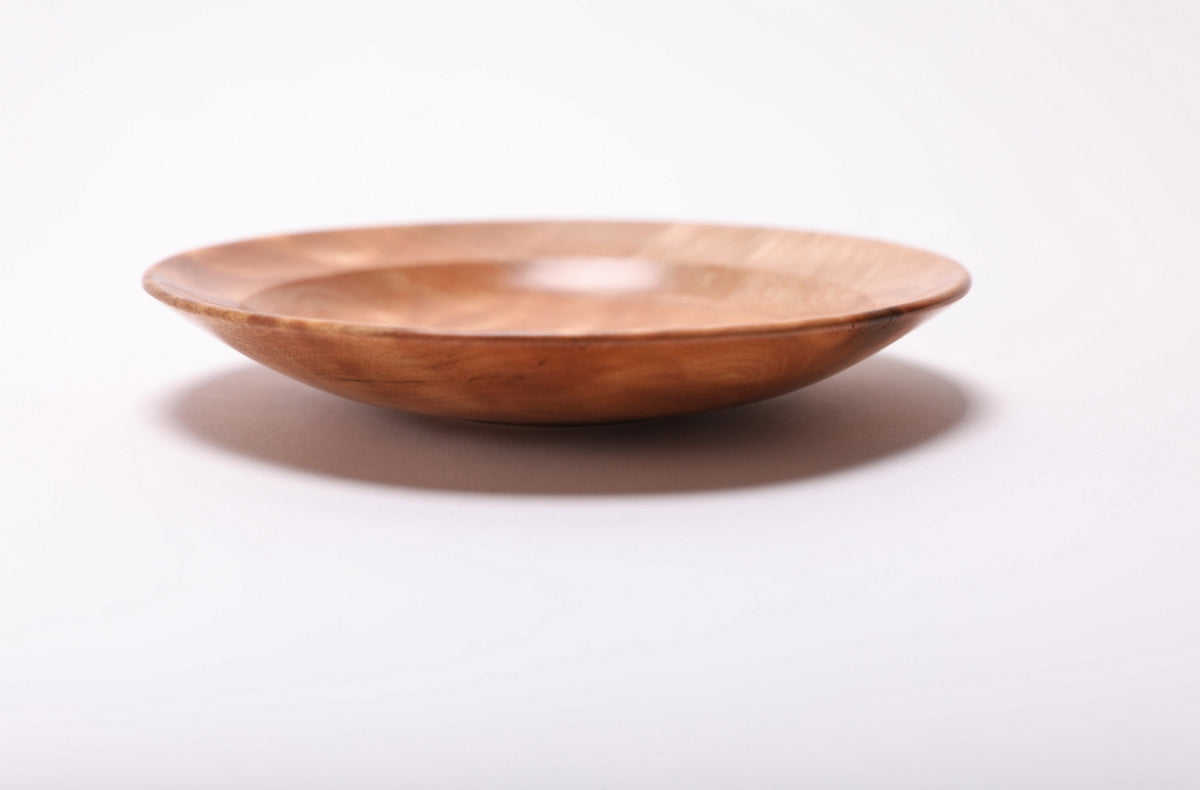 Side view of the shallow maple ring dish, showing its rounded rim, curved tapering sides, and low raised foot.