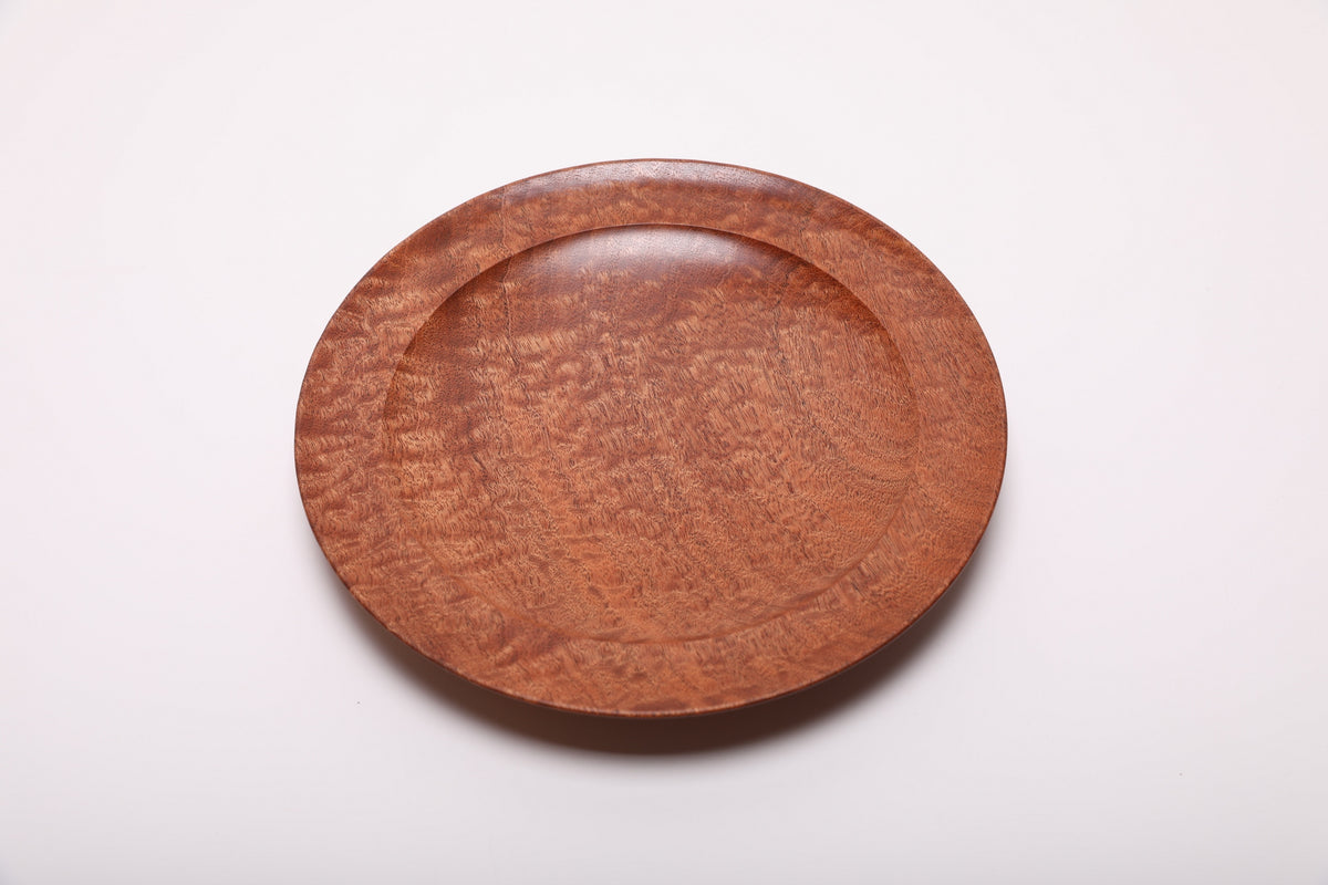Top view of the sapele bowl at another rotation, with warm rust-colored grain and subtle golden highlights.