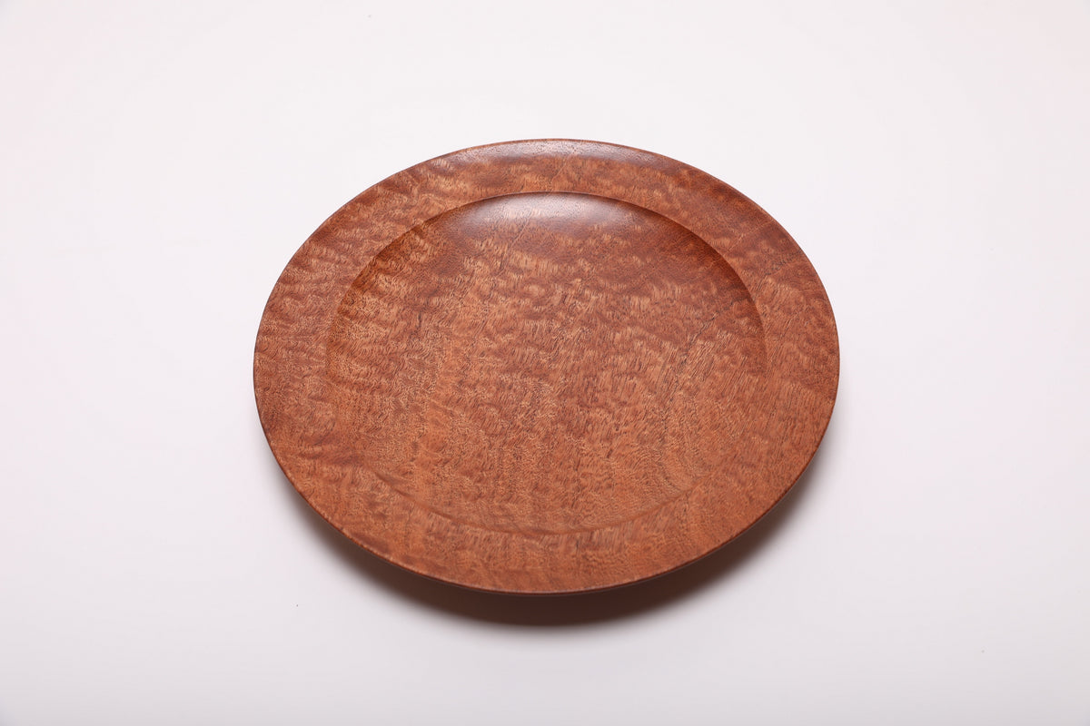 Shallow pommele sapele bowl showing fine dappled figure across the interior and rounded rim.