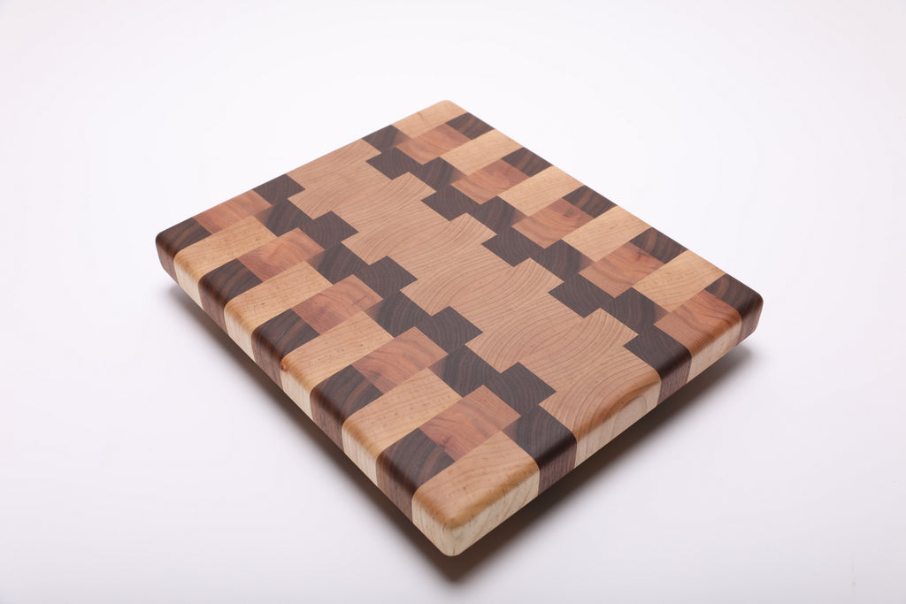 Diagonal top view of the maple, walnut and cherry cutting board showing its geometric end grain pattern.