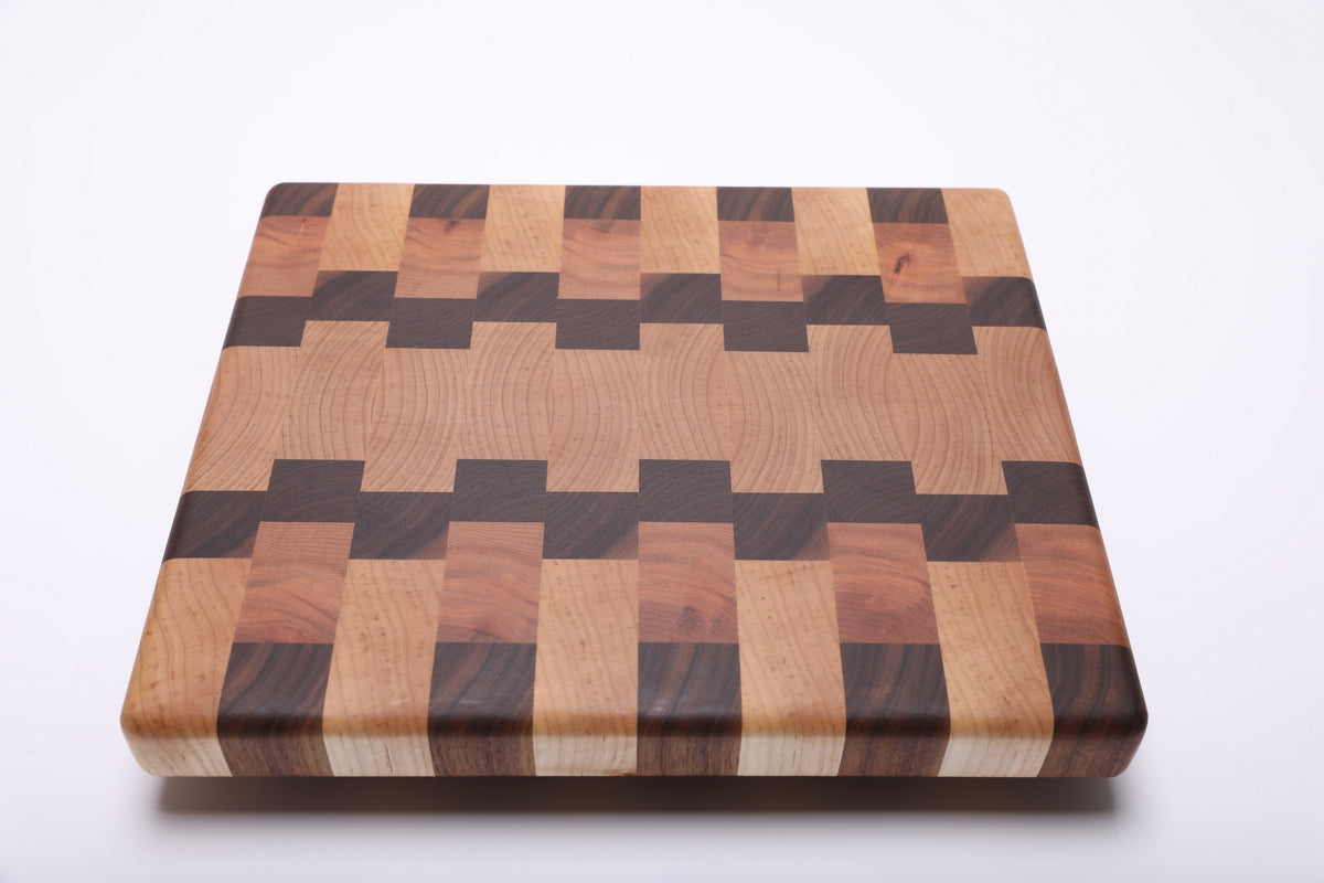 Top view of the cutting board showing fine end grain in the pale center and dark stepped bands along both sides.