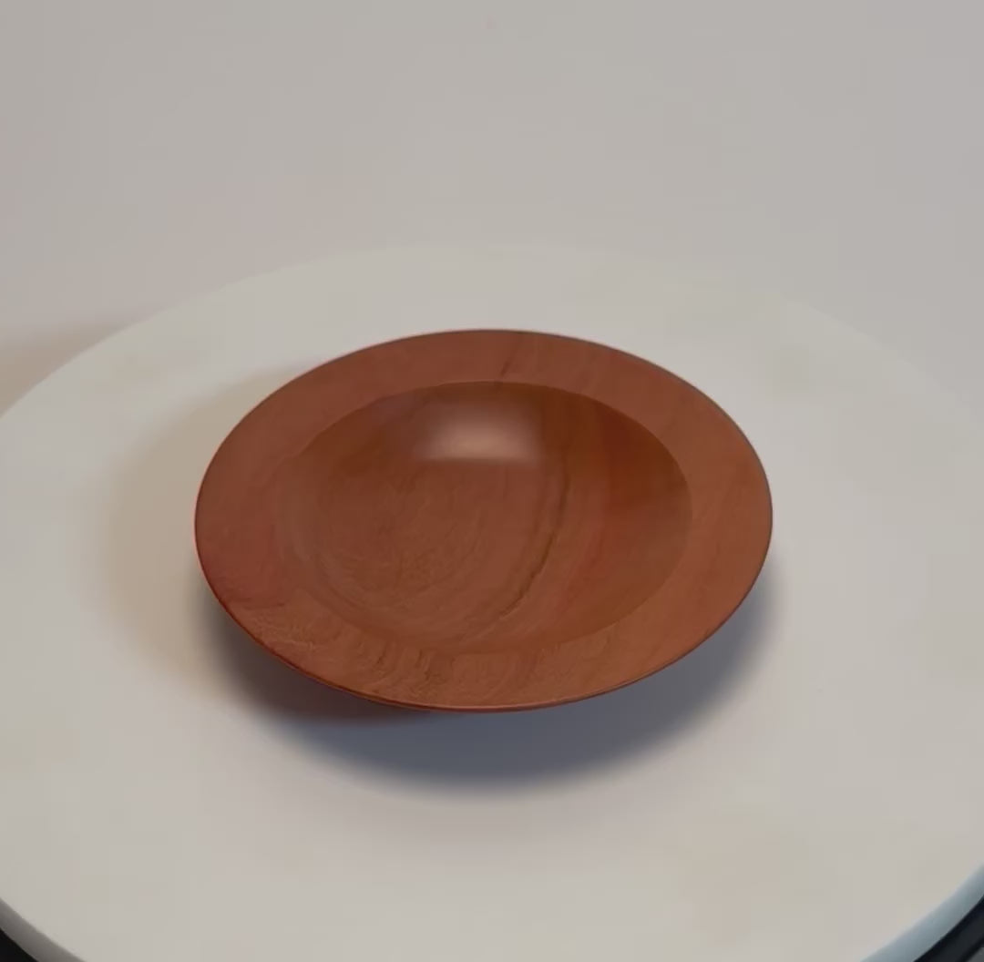Wild black cherry wooden ring dish rotating 360° on display stand, showcasing bullseye figure, amber growth rings, red highlights, and handcrafted oil finish — Sanders Woodworking
