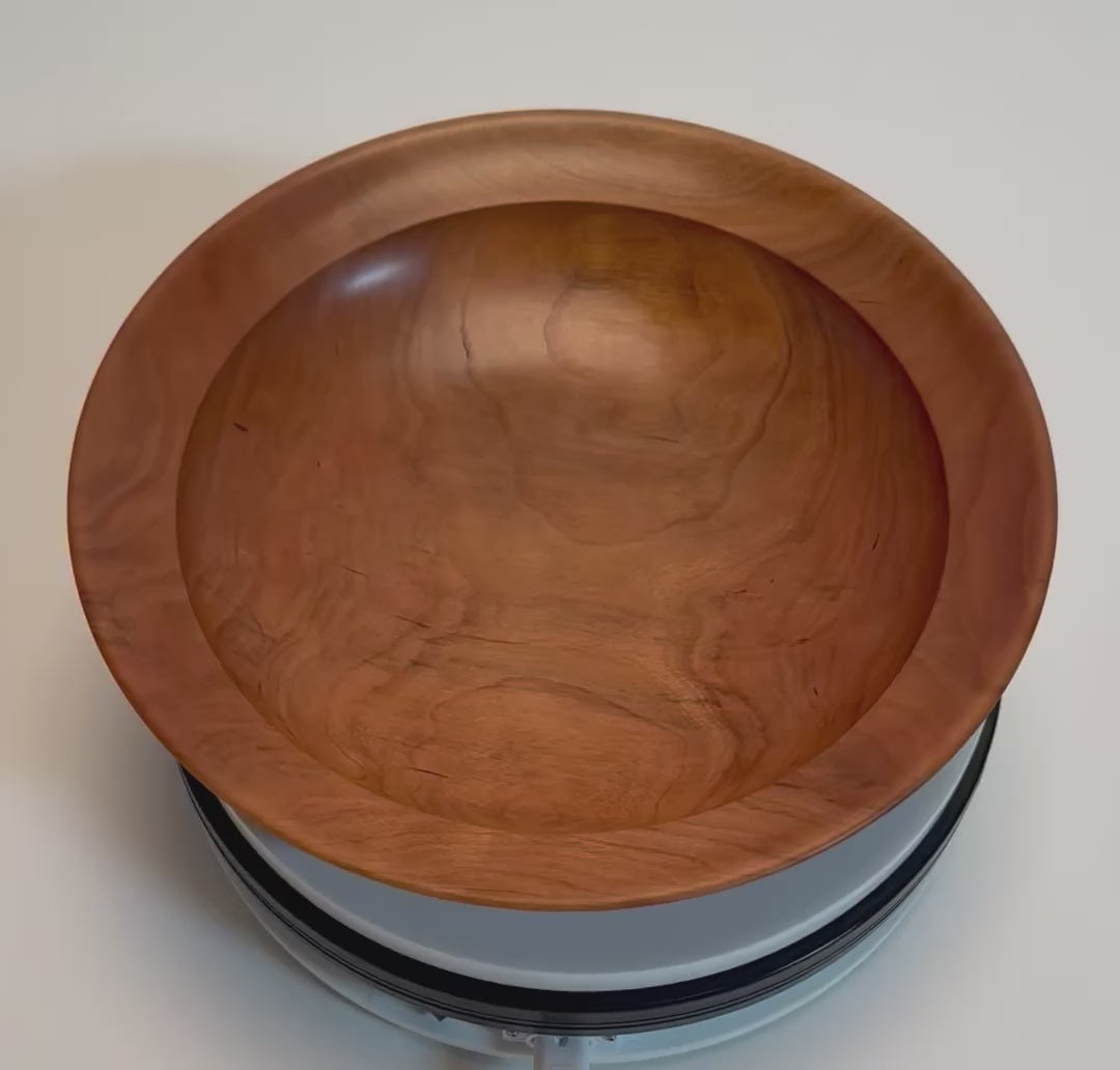 Handcrafted wild black cherry wooden bowl rotating on display stand – 360° view of rich orange-pink grain, amber growth rings, and natural oil finish	