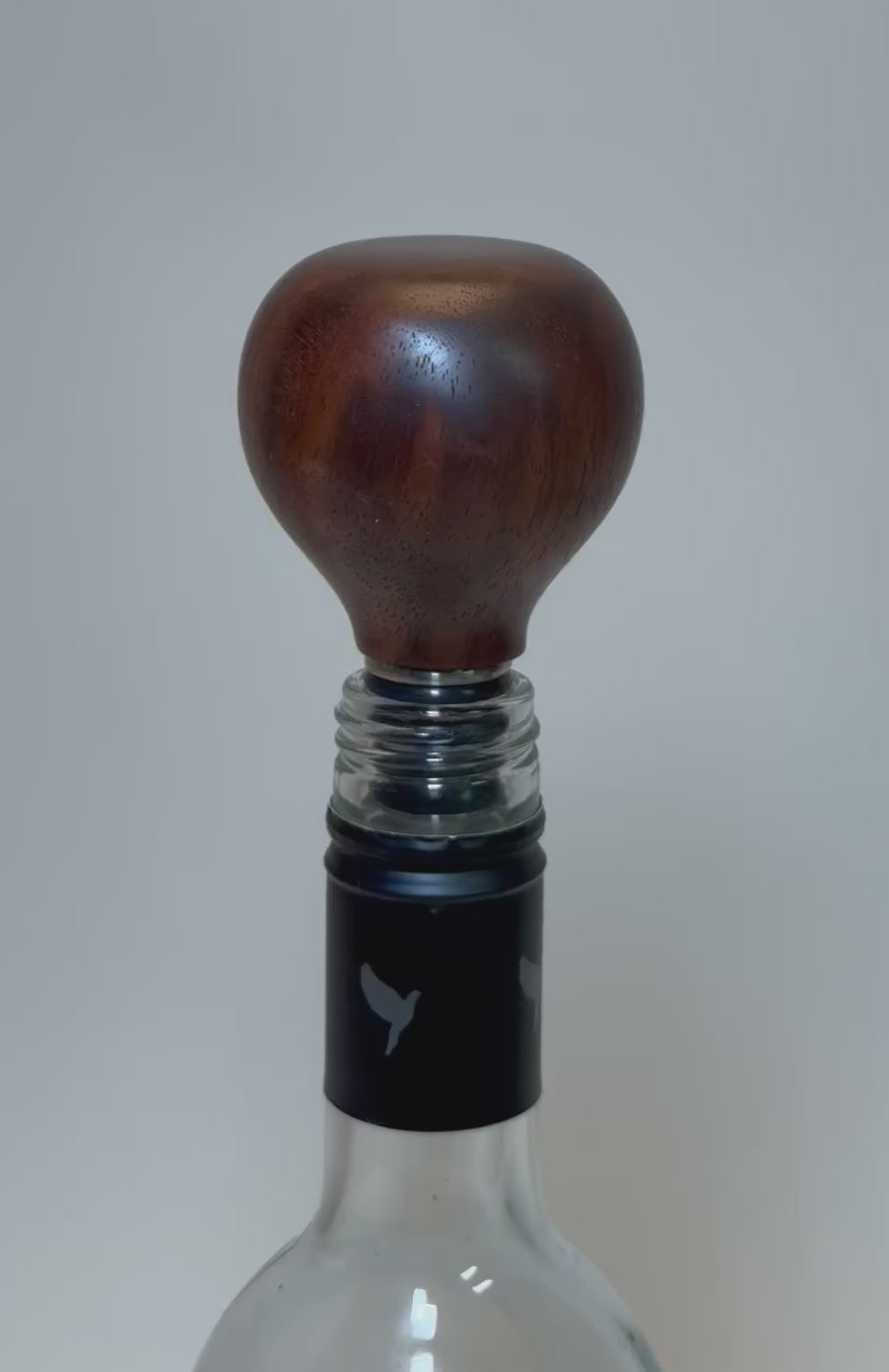 Video showcasing walnut burl wine stopper with red highlights and chocolate brown grain patterns