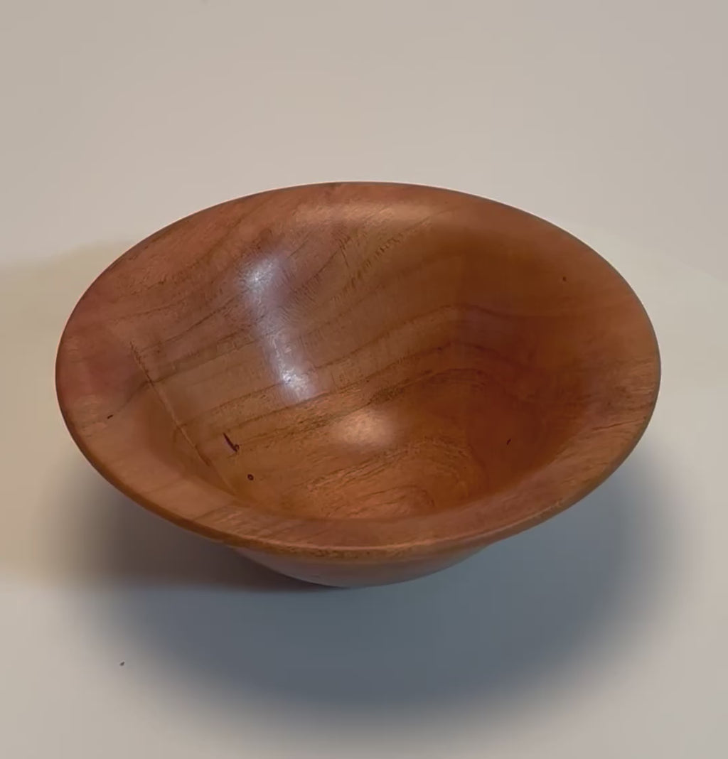 Small wild black cherry wooden bowl rotating 360 degrees on display stand showing rich color, growth ring transition lines, and natural wormholes, Sanders Woodworking