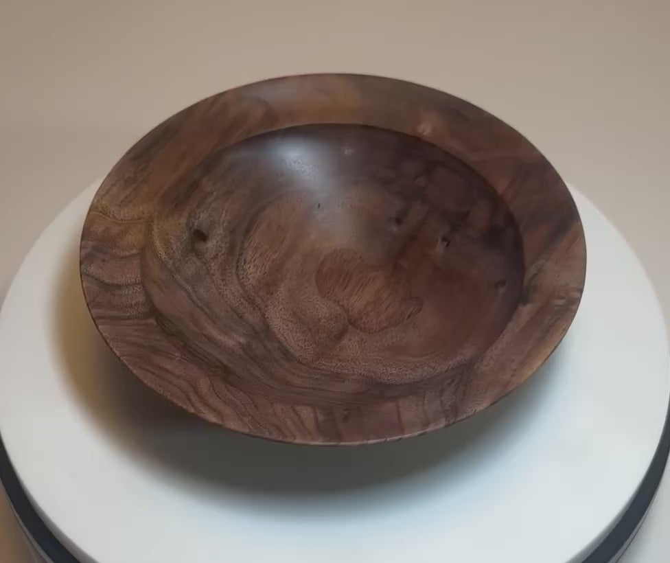 Curly wild black walnut wooden bowl rotating 360° on display stand, showcasing curly growth rings, bud scars, sand to dark chocolate tones, and handcrafted oil finish — Sanders Woodworking