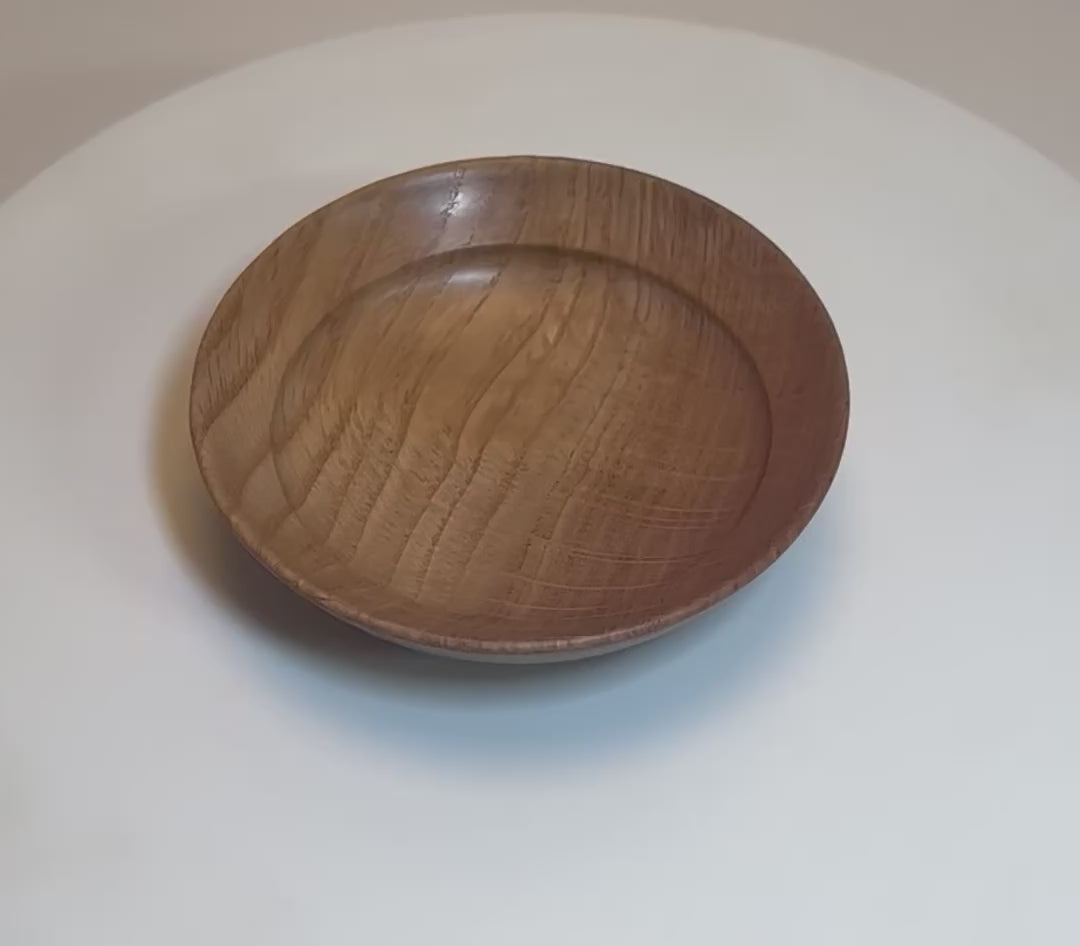 Quartersawn white oak wooden ring dish rotating 360° on display stand, showcasing shooting star rays, amber growth rings, and handcrafted oil finish — Sanders Woodworking