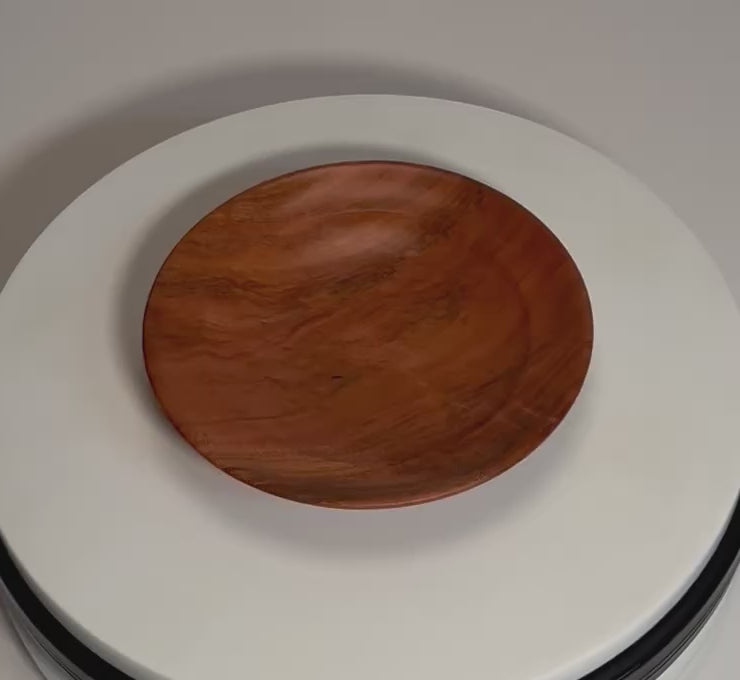 Hand-turned wild black cherry burl ring dish rotating on display stand, showing deep pink-orange grain, burl figure, curved profile, and natural oil finish from all angles