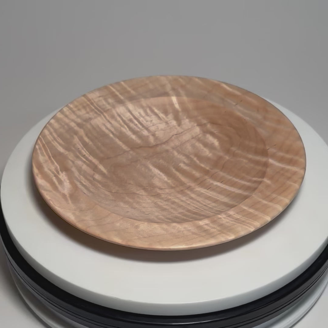 Tiger maple wooden dish on a rotating display, showing its shimmering tiger figure changing with the light.