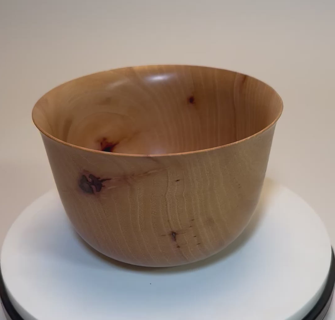 360-degree view of hand-turned pecan Liberty Bell bowl showing bell rim, bark inclusions, and natural wood finish