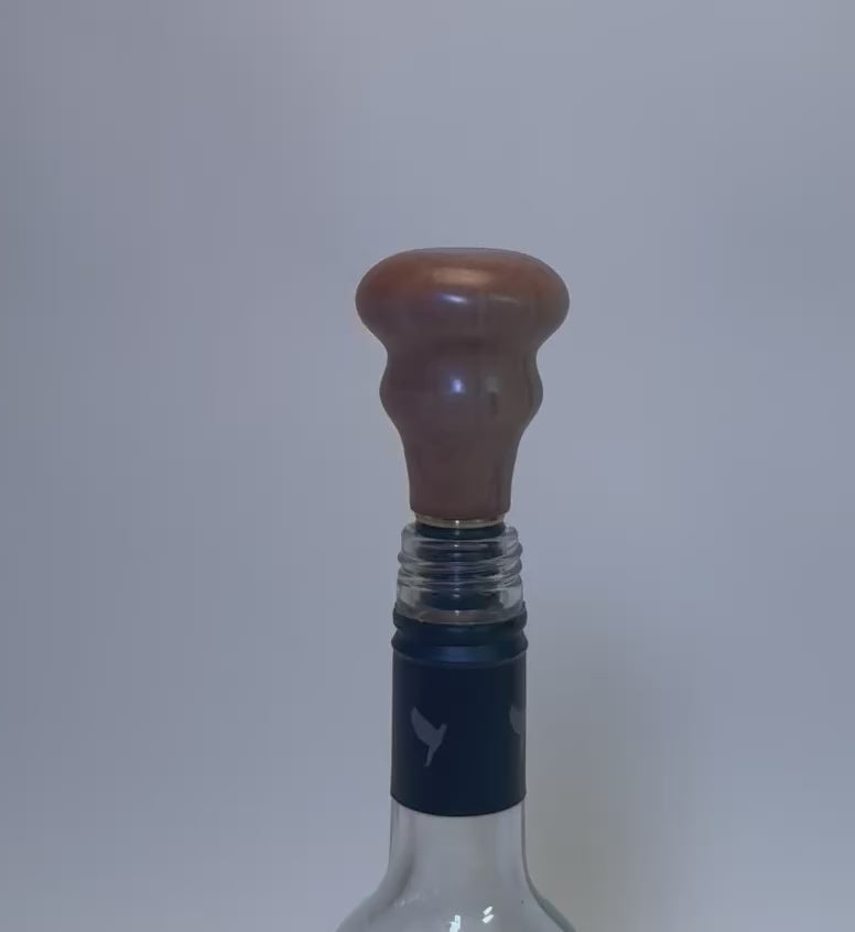 360-degree view of pear wood wine stopper showing warm grain, brass fitting, and natural oil finish
