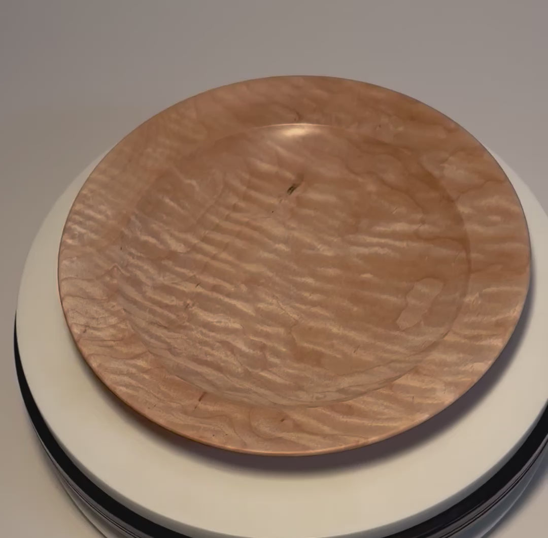 Handcrafted curly quilted maple shallow bowl rotating on display stand – 360° view of rare chatoyant quilt figure and amber growth rings	
